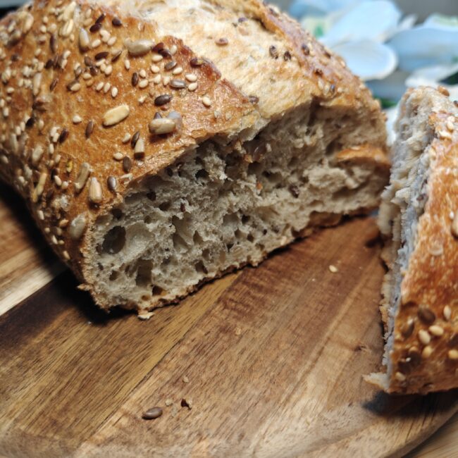 Baked sourdough seeded bread cooling on wire rack with seeds crust